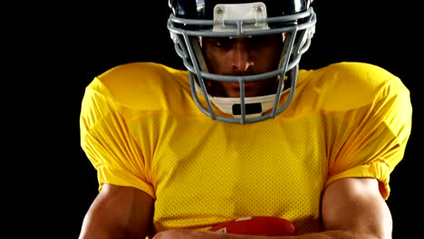 American-football-player-holding-ball-against-black-background-4k