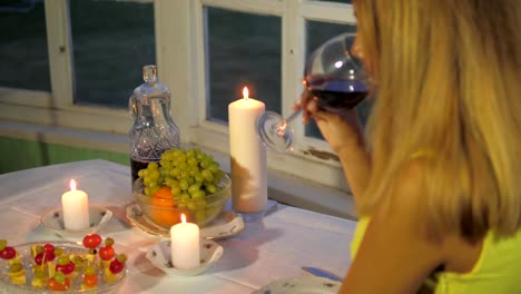 Mujer-en-el-restaurante-una-mesa-con-canapés-y-frutas,-beber-vino