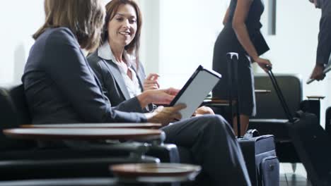 Caucasian-female-business-managers-using-technology-in-airport