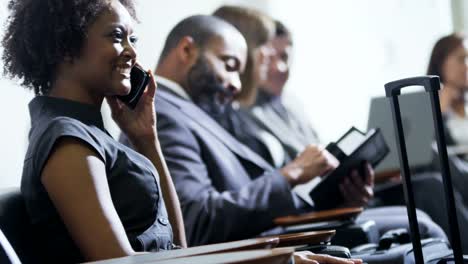 Ethnic-female-financial-executive-using-smartphone-in-airport