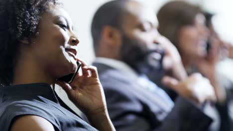 Multi-ethnic-commuters-using-smartphone-in-airport-lounge