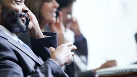 Ethnic-businessman-enjoying-news-using-smartphone-in-airport