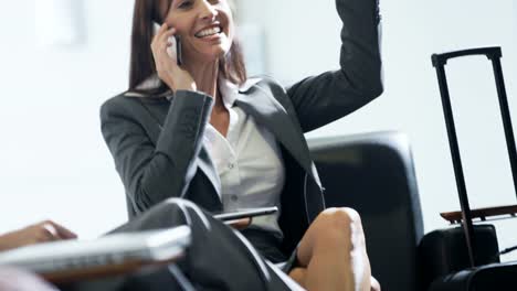 Caucasian-American-businesswoman-using-smartphone-technology-in-airport