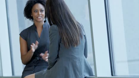 Multi-ethnic-female-business-travellers-talking-in-airport