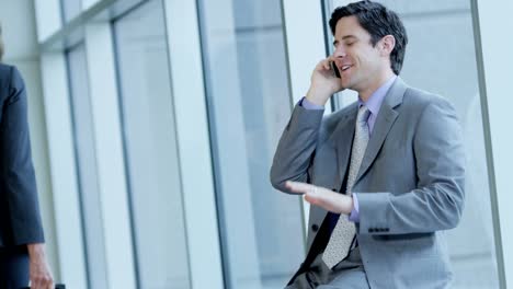 Businessman-enjoying-good-news-on-smartphone-in-airport