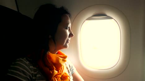 Attractive-woman-looks-out-of-airplane-window