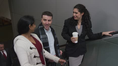 Businesspeople-on-escalator-talking