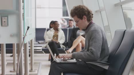 Man-using-laptop-at-airport