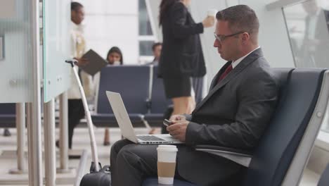 Businessman-using-laptop-at-airport