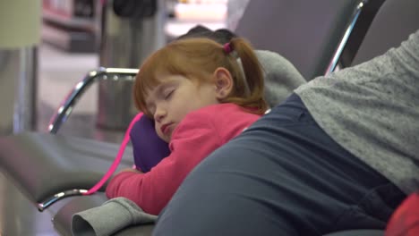 Mädchen-und-Momsleeping-im-Bereich-Flughafen-warten.-Flugverspätung