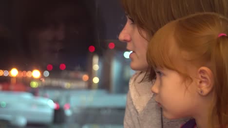 A-little-girl-with-mom-looks-at-the-airplanes-at-the-airport