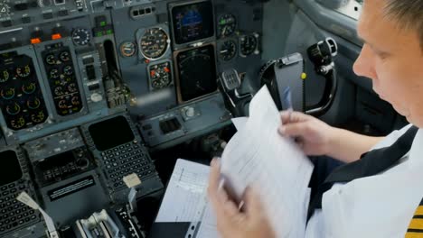 Captain-of-airplane-checks-documents-before-flight