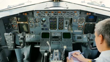 Pilot-checks-doments-sitting-in-cockpit