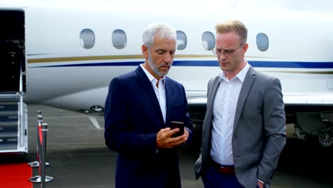 Businessmen-discussing-over-mobile-phone-4k