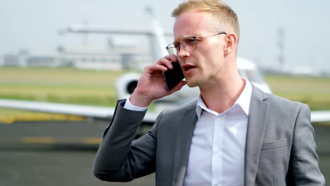 Businessman-talking-on-mobile-phone-at-terminal-4k