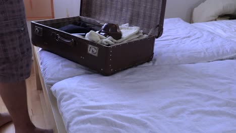 A-man-packs-a-suitcase-on-vacation,-slow-motion-video