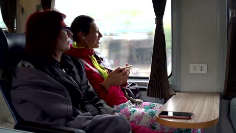 Women-sit-on-the-train-and-talk