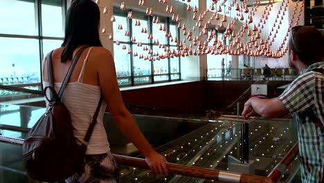 A-woman-and-man-looks-at-the-kinetic-rain-at-the-Singapore-airport