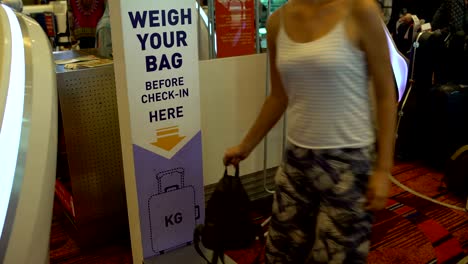 A-woman-checks-the-weight-of-the-baggage-at-the-airport