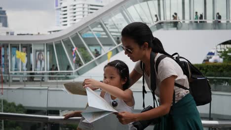 Mother-and-daughter-looking-a-map-backpack-travel-in-the-city