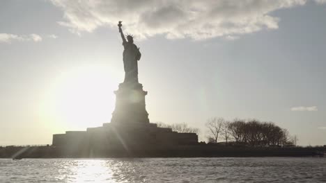 Medium-shot-der-Statue-of-Liberty,-gefilmt-in-den-Sonnenuntergang-vom-Fluss-in-New-York,-Vereinigte-Staaten-von-Amerika