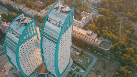 Silhouette-des-doppelten-hoch-Skyscrapper-mit-Brücke-zwischen-ihnen-gegen-Sonnenuntergang