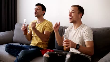 Dos-excitaron-a-hombres-adultos-bebiendo-cerveza-y-viendo-el-partido-de-fútbol-indoor-en-la-tv.-Celebrando-la-victoria.-Cierre-para-arriba