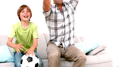 In-slow-motion-happy-father-and-son-watching-football