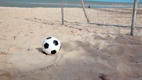 Fútbol-y-objetivo-en-la-playa-de-arena-y-el-cielo-azul-de-fondo-de-tracking,-dolly-en-HD-de-tomas-a-cámara-de-luz-de-día