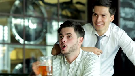 Two-successful-friends-businessmen-drink-beer-and-rejoice-and-shout-together