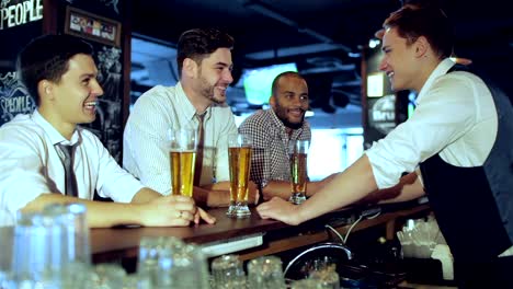 Three-friends-sitting-at-the-bar-and-keep-the-beer