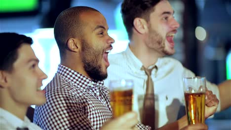 Herren-fans-winkt-Ihre-Hände-und-sich-ein-Fußballspiel-auf-dem-Fernseher-und-Trinken-Bier