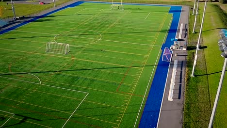 Volando-sobre-un-campo-de-fútbol-americano-de-síntesis-al-aire-libre