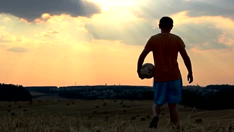 Hombre-jugando-con-un-balón-en-el-campo-al-atardecer,-hombre-jugando-al-fútbol-al-amanecer