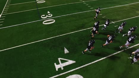 The-camera-spins-from-above-as-a-football-team-in-a-huddle-gets-hyped-and-runs-onto-the-field