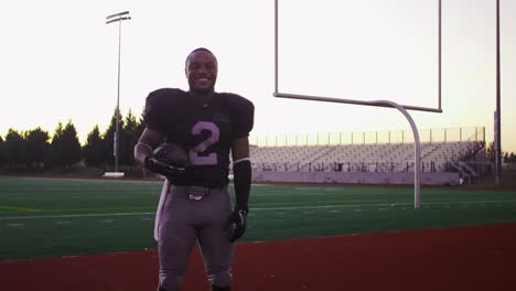 Portrait-of-a-football-player-on-a-field-catching-a-football