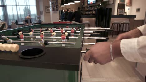 Junges-Paar-spielen-in-Tischfußball