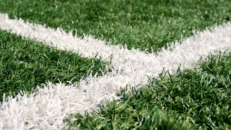 Close-up-of-the-out-of-bounds-line-on-a-turf-football-field