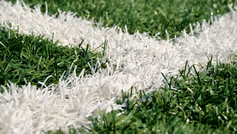 Close-up-of-the-out-of-bounds-line-on-a-turf-football-field