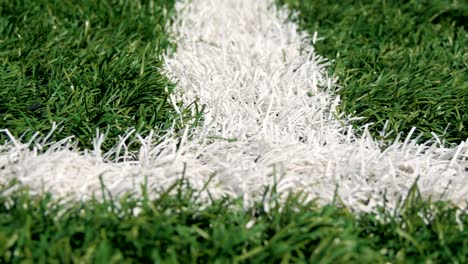 Close-up-of-the-out-of-bounds-line-on-a-turf-football-field