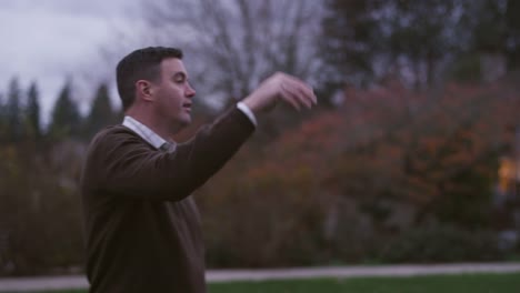 Un-padre-pasa-un-balón-de-fútbol-a-su-hijo-en-un-parque-de-noche,-cámara-lenta