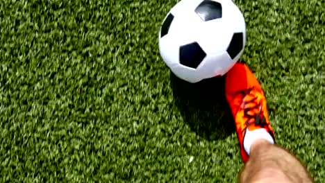 Footballer-with-orange-shoes-leading-the-ball,-top-view