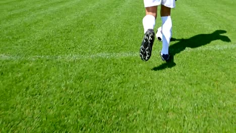 Futbolista-llevando-la-pelota-en-un-campo-de-fútbol