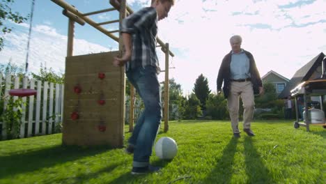 Grandfather-and-Grandson-Play-Football-in-the-Backyard.