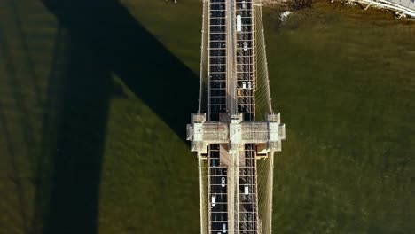 Top-aerial-view-of-the-traffic-road-on-the-Brooklyn-bridge-through-the-East-river-in-New-York,-America