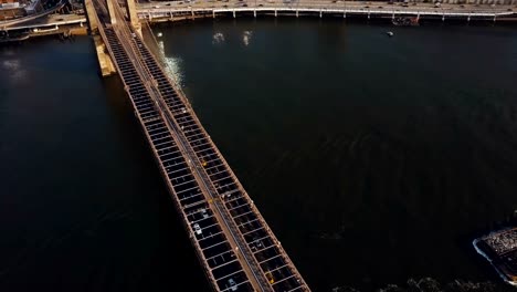 Superior-vista-aérea-del-puente-de-Brooklyn,-famoso-lugar-de-interés-en-Nueva-York,-América.-Vista-del-tráfico-por-carretera-y-río-del-este