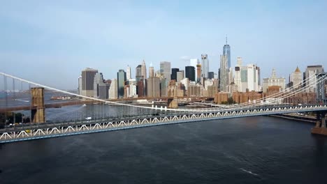 Vista-aérea-de-Nueva-York,-América.-Drone-volando-bajo-del-puente-de-Manhattan-hasta-el-puente-de-Brooklyn-a-través-del-río-del-este