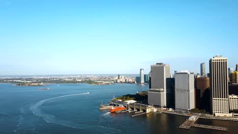 Aerial-view-of-the-Statue-of-liberty-in-the-distance,-Manhattan,-East-river-in-Manhattan-in-New-York,-America