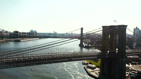 Vista-aérea-de-Nueva-York,-América.-Drone-volando-sobre-el-puente-de-Brooklyn-hasta-el-puente-de-Manhattan-a-través-del-río-del-este