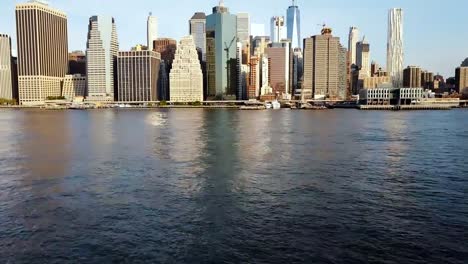 Vista-aérea-de-la-famosa-ciudad-de-Nueva-York,-Estados-Unidos,-Distrito-de-negocios-de-Manhattan.-Drone-volando-bajo-sobre-el-East-river-y-el-muelle